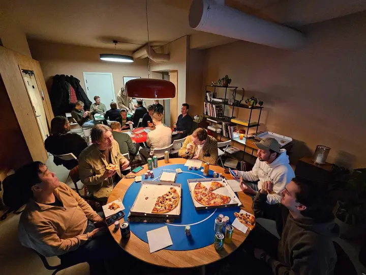 Pizzapause. Esker på det blå bordet, resten av rommet i bakgrunnen.